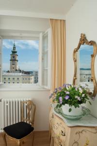 林茨Austria Classic Hotel Wolfinger - Hauptplatz的一间设有花瓶和窗户的桌子的房间