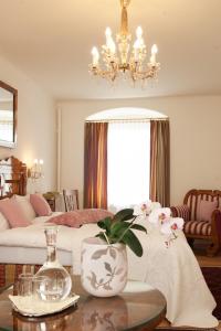 林茨Austria Classic Hotel Wolfinger - Hauptplatz的客厅配有床和带花瓶的桌子