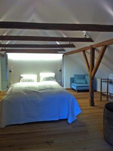 费尔德基兴沃德兰德格勒根度假屋的卧室配有白色的床和蓝色的沙发