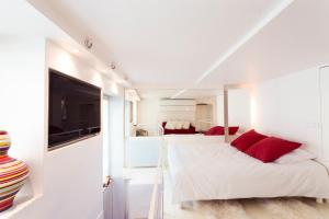 巴黎时尚豪华巴黎市中心复式公寓的一间卧室配有一张带红色枕头的床和一台电视。