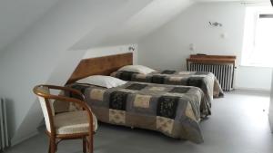 欧丹库尔杜汝拉酒店的白色客房的两张床,配有椅子和一张四柱床
