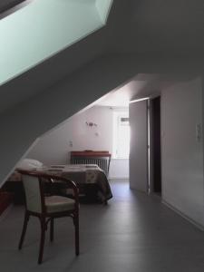 欧丹库尔杜汝拉酒店的卧室配有1张床、1张桌子和1把椅子