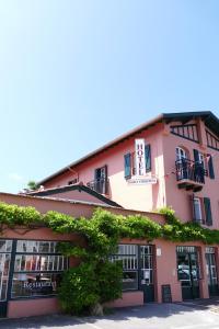 圣让-德吕兹Boutique hôtel Maria-Christina的粉红色的建筑,上面有标志