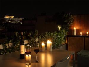 雅典雅典景致阁楼 - 01公寓的一张桌子,上面放两杯葡萄酒和两根蜡烛