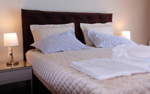 雷夫卡达镇Kamares Luxury Apartments的一张带白色床单和枕头的床