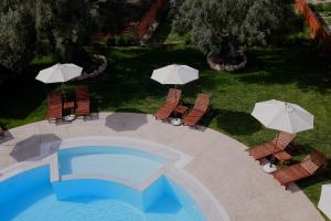 雷夫卡达镇Kamares Luxury Apartments的享有带遮阳伞的游泳池的顶部景致