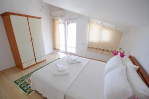 达特恰Kaya Apart Datca的卧室设有一张白色大床和一扇窗户。