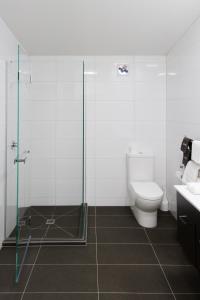 但尼丁欧罗拉乔治酒店的一间带卫生间和玻璃淋浴间的浴室