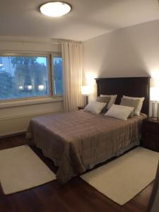 库奥皮奥City Apartment Sairaalakatu的一间卧室设有一张大床和大窗户