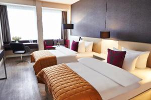 科隆科隆施泰根博阁酒店的酒店客房设有两张床和休息区。