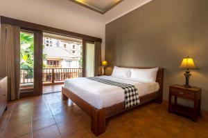 努沙杜瓦维迪精品酒店的一间卧室设有一张床和一个大窗户