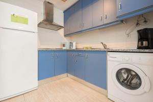 塔里法Apartamento Castillejos的厨房配有蓝色橱柜和洗衣机。