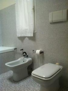 因佩里亚Cà Mea的白色的浴室设有卫生间和水槽。