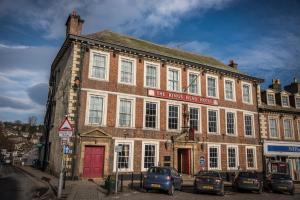 里士满The Kings Head Hotel, Richmond, North Yorkshire的街上有红门的旧砖砌建筑