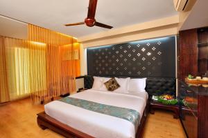 ShoranūrThe River Retreat Heritage Ayurvedic Resort的一间卧室配有一张大床和黑色床头板