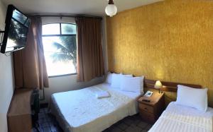 马卡埃贝拉特里克斯酒店的酒店客房设有两张床和电视。