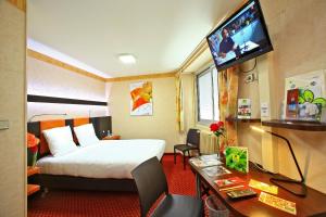 永河畔拉罗什Le Point Du Jour的酒店客房配有一张床、一张书桌和一台电视。