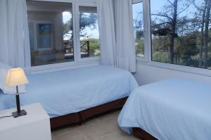 马德拉潘帕斯Jaina Resort & Spa的一间卧室设有两张床和两个窗户。