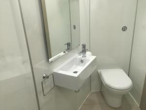 欧文The Harbour Guest House的白色的浴室设有水槽和卫生间。