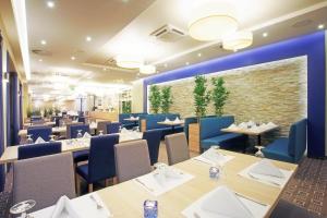 凯蒂赖贝西Tristan Hotel & SPA的一间配备有桌子和蓝色椅子的用餐室