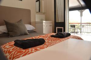 Gatton皇家加顿酒店的一间卧室配有一张床,上面有两条毛巾