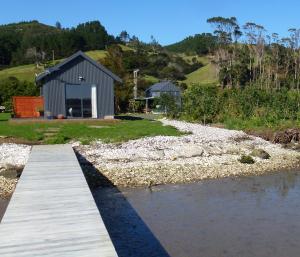 科罗曼德镇Oystercatcher Bay Boathouse的一条通往河边房屋的木道