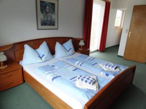 奥西阿赫Pension Neuhof的一张带蓝色和白色床单及枕头的床