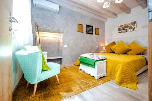 罗维尼Casa Smeralda的一间卧室配有黄色的床和蓝色椅子