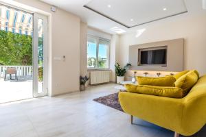 马林斯卡Apartments & Rooms Milcetic M的客厅设有黄色沙发和电视