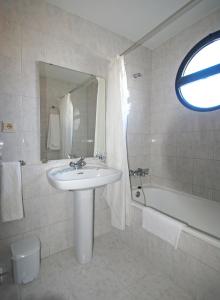 Chauchina马里尼托酒店的白色的浴室设有水槽和浴缸。