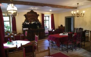 阿尔滕堡Hofgärtnerei的一间用餐室,配有两张带红色桌布的桌子