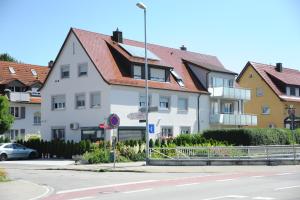 腓特烈港Ferienzimmer Ellisee, kontaktloser Check-in的一条白色的建筑,在街道旁有红色的屋顶