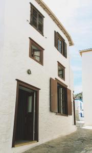 伊兹拉Alleyway House的白色的建筑,设有棕色的窗户和门