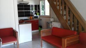 锡拉奥莱斯克里奥尔花园公寓的一间带两张红色椅子和楼梯的厨房
