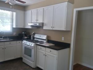 滨湖尼亚加拉Westwood Cottage License #045-2020的厨房配有白色橱柜和炉灶烤箱。