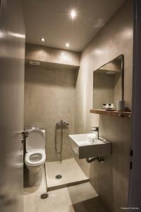 内欧斯皮尔戈斯Kochili Apartments的一间带卫生间、水槽和镜子的浴室