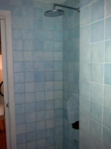 泰拉奇纳Torrione San Lorenzo I的浴室设有蓝色和白色瓷砖淋浴。