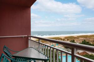大洋城大洋城假日酒店的阳台配有桌子,享有海滩美景