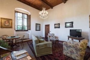潘札诺Relais Fattoria Valle的客厅配有家具和吊灯。