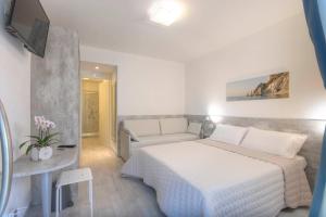努马纳Affittacamere da Sabri的卧室配有白色的床和沙发