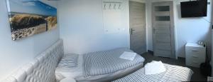 格丁尼亚Panorama Gdynia Rooms的小房间设有床和电视