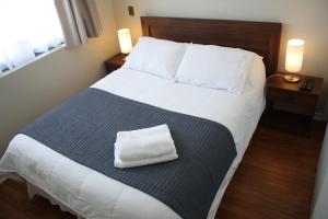 康塞普西翁Hostal Buró的一间卧室配有一张大床,上面有毛巾