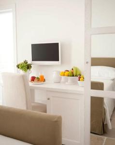 滨海波利尼亚诺多娜帕斯卡住宿加早餐旅馆的一张带一碗水果的白色桌子和一台电视机
