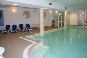 巴塞尔加·迪·皮纳奥林匹克酒店的一个带蓝色椅子的大型游泳池