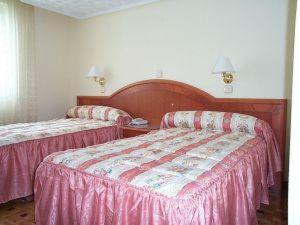 Villafría de Burgos布宜诺斯艾利斯酒店的两张位于酒店客房的床铺,配有粉红色床单