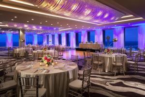 达拉斯达拉斯市中心威斯汀酒店的宴会厅配有白色桌椅和紫色照明