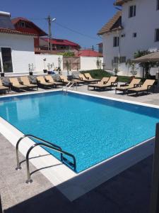 曼加利亚Hotel MaRailiS Mangalia的一个带躺椅的游泳池和一个游泳池