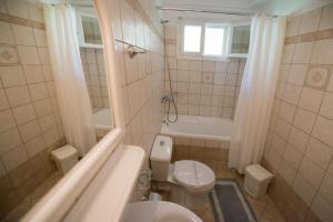 尼基亚娜Sofia Hotel的浴室配有卫生间、浴缸和水槽。