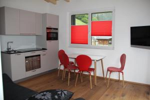格舍嫩Haus Steiner的一间厨房,内设红色椅子和桌子
