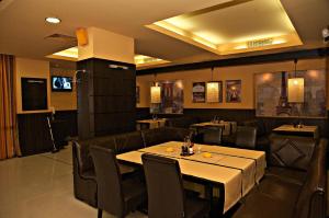 Silistra社迪卡酒店的一间带桌子和皮革椅子的用餐室